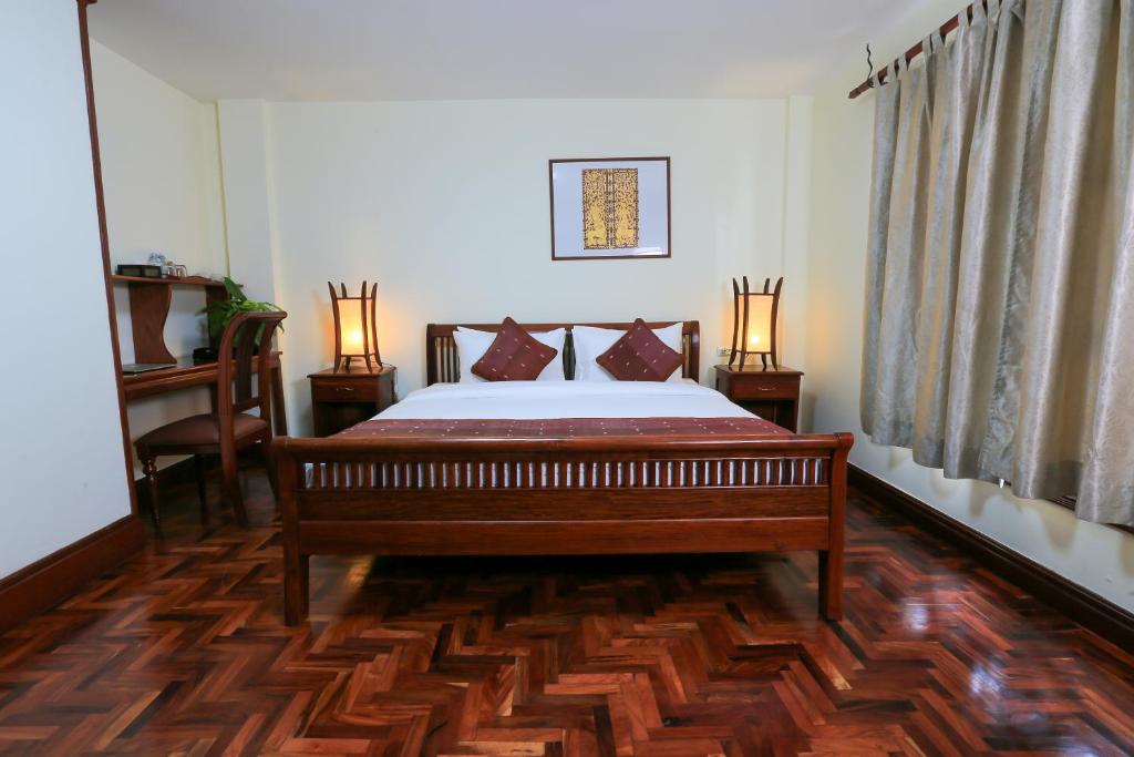 a bedroom with a bed and two lamps in it at Phongsavath Boutique Hotel in Vientiane