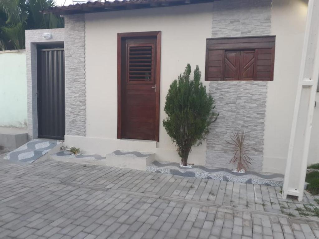 a house with a door and a plant in front of it at Casa Completa Prox Centro de Pipa in Pipa