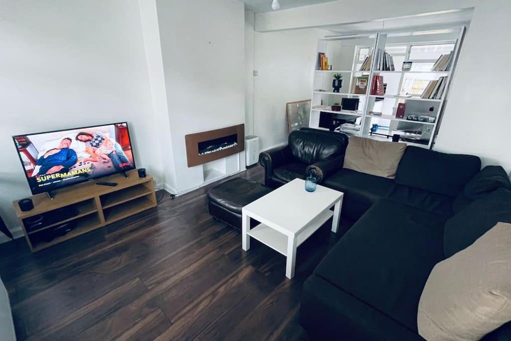 sala de estar con sofá negro y TV en City Loft - O2 & Excel Center en Londres
