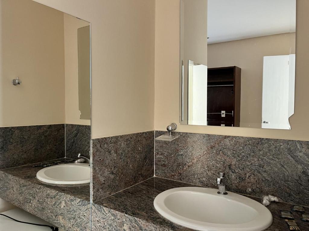 a bathroom with two sinks and a mirror at Tropical Palace Hotel in Lavras