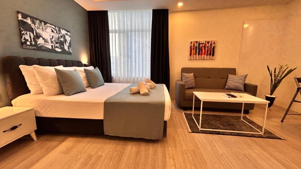 una camera con un grande letto e un divano di HADRİANS TOWER a Antalya (Adalia)