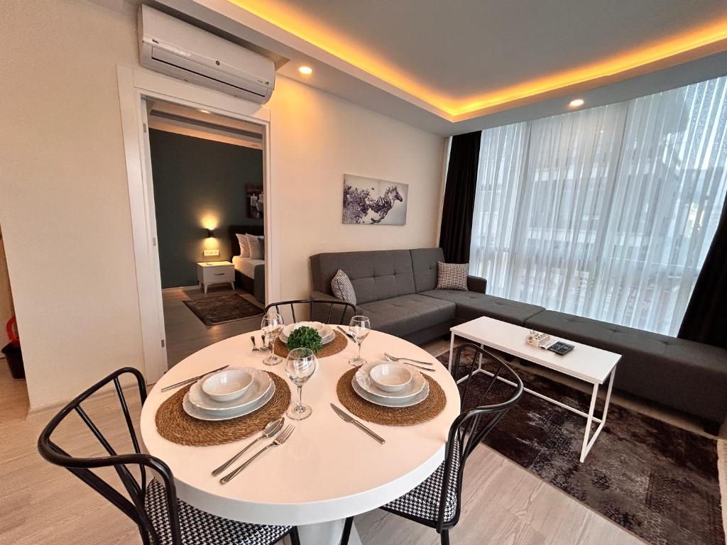 a living room with a table and chairs and a couch at HADRİANS TOWER in Antalya