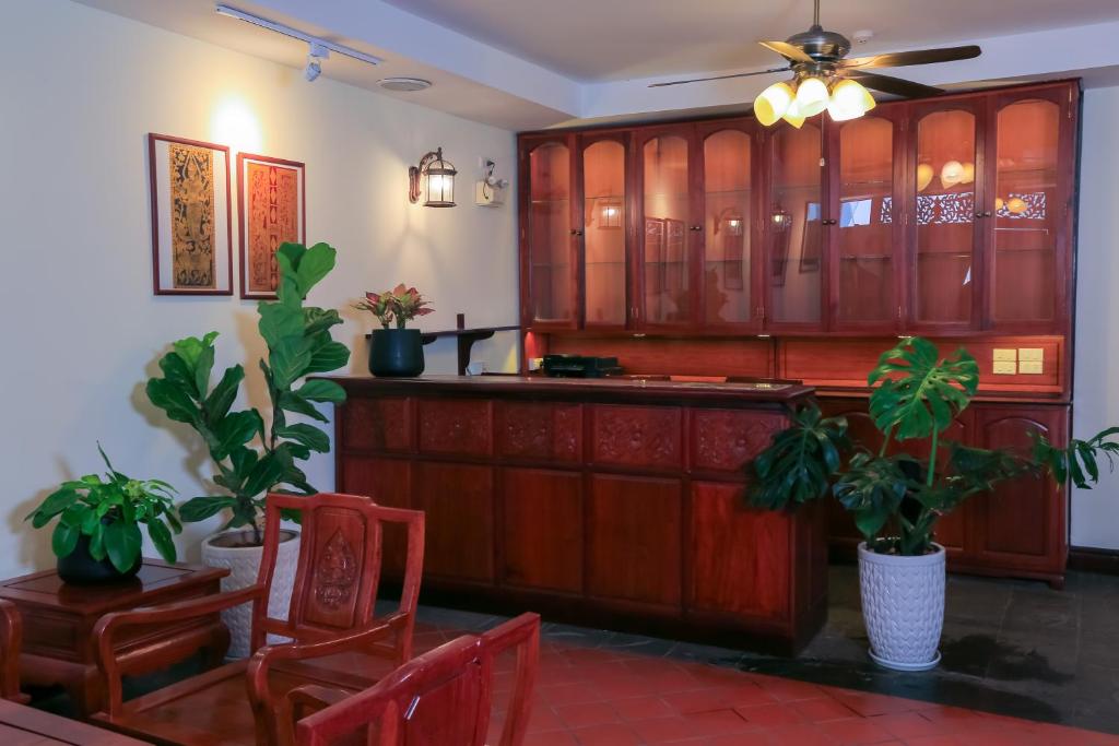 a kitchen with wooden cabinets and potted plants at Phongsavath Boutique Hotel in Vientiane