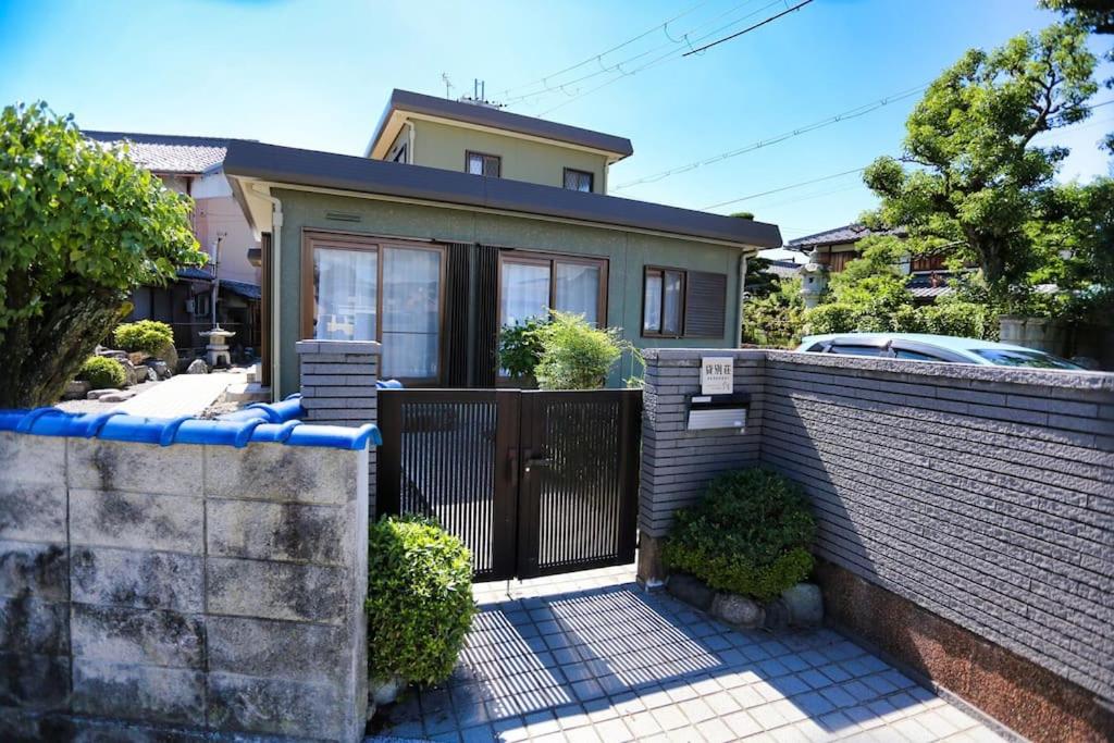 uma casa com um portão e uma cerca em 貸別荘せせらぎ em Taga