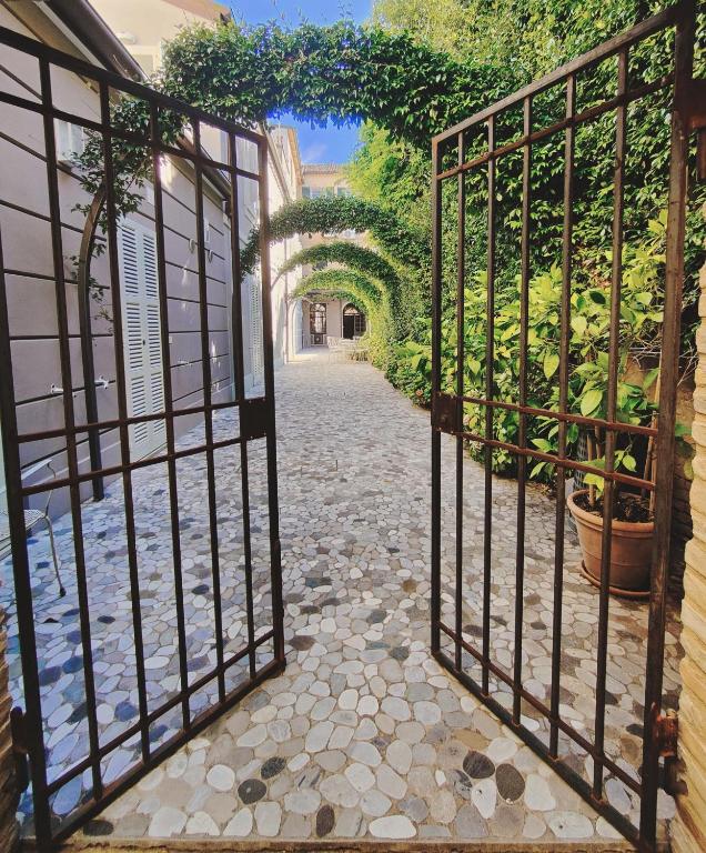 an iron gate leading to a walkway with plants at Le Case Cavour in Ravenna