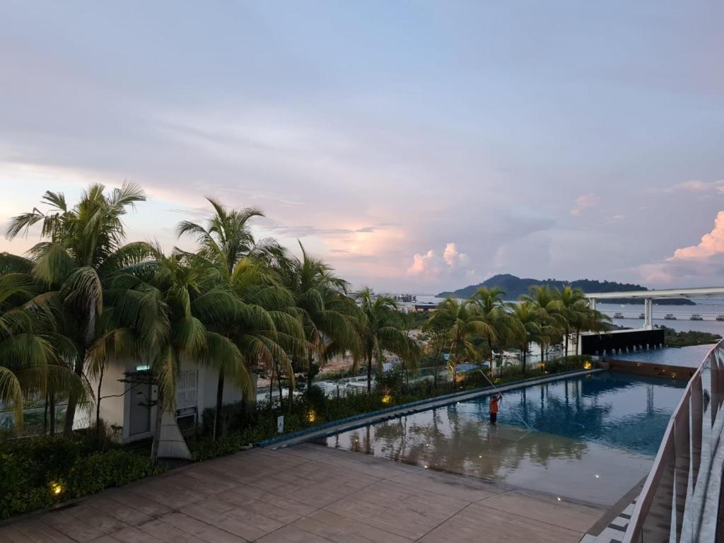 バヤンレパスにあるSeaview Condo 10pax #10minQueensbay #15minSpiceのヤシの木が茂るスイミングプールの景色を望めます。