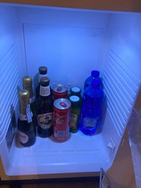a refrigerator filled with bottles and cans of drinks at Duomo Suites Florence in Florence