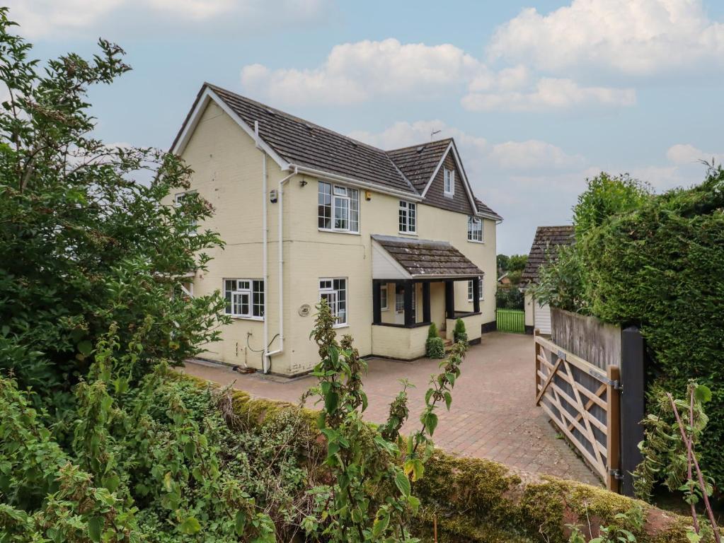 een wit huis met een hek ervoor bij Church Cottage in Diss