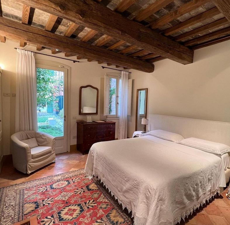 una camera con un letto e una sedia e una finestra di Le Case Di San Vitale Easy a Ravenna