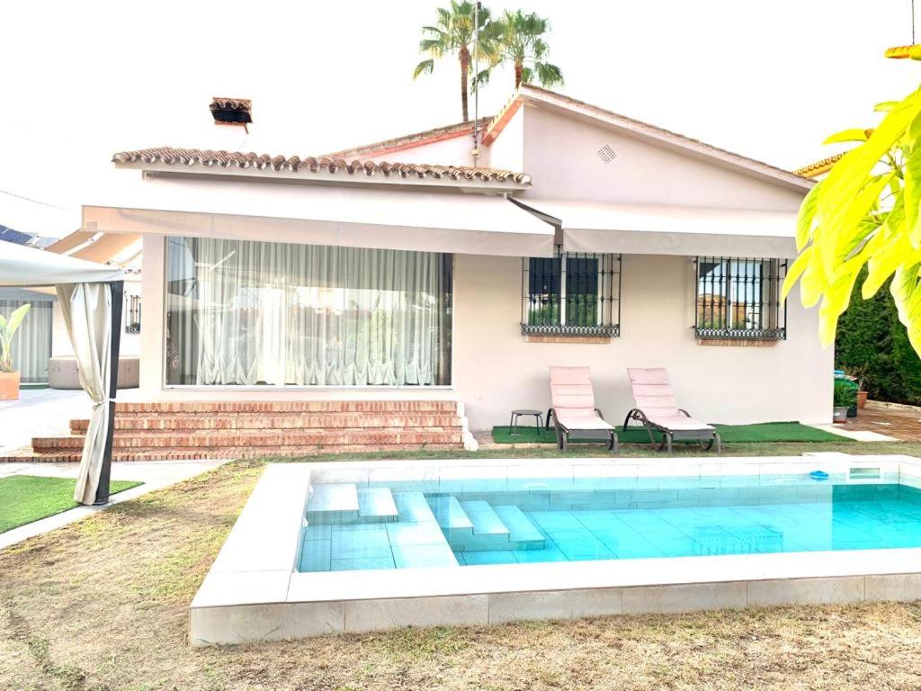 a swimming pool in front of a house at Villa AURA 500 metros de la playa in Torre de Benagalbón