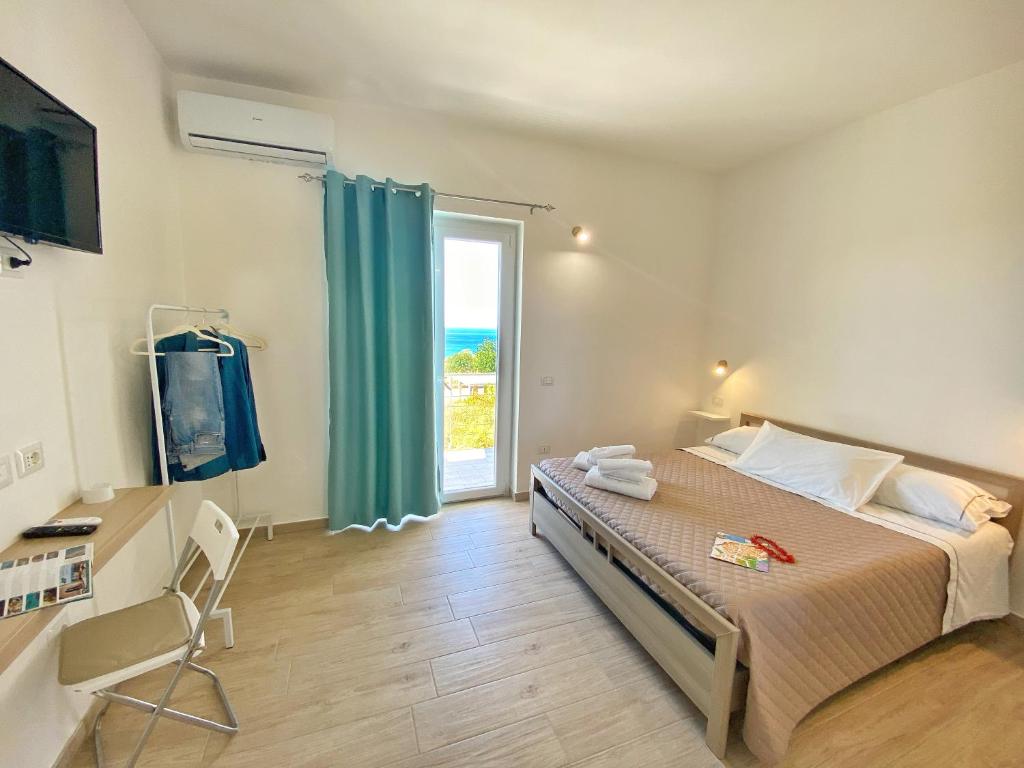 a bedroom with a bed and a large window at Campus Dei - Tropea Rooms in Tropea