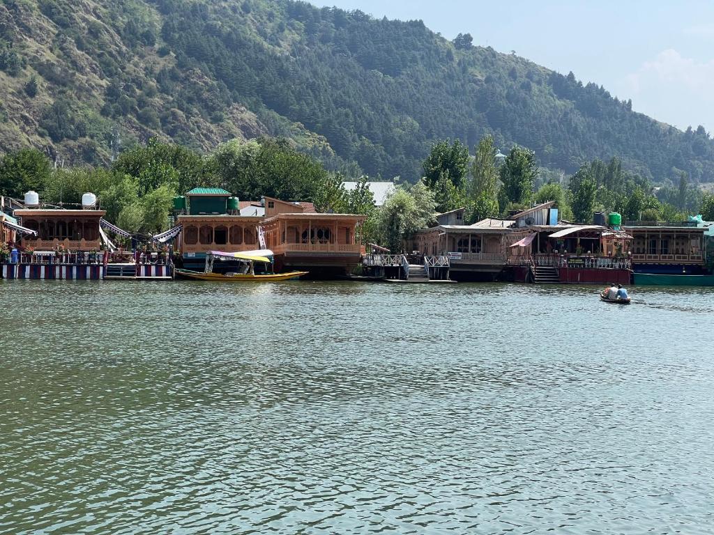a group of houses on the water near a mountain at ARISTOTLE GROUP OF HOUSEBOATS & TRANSPORTATION in Srinagar
