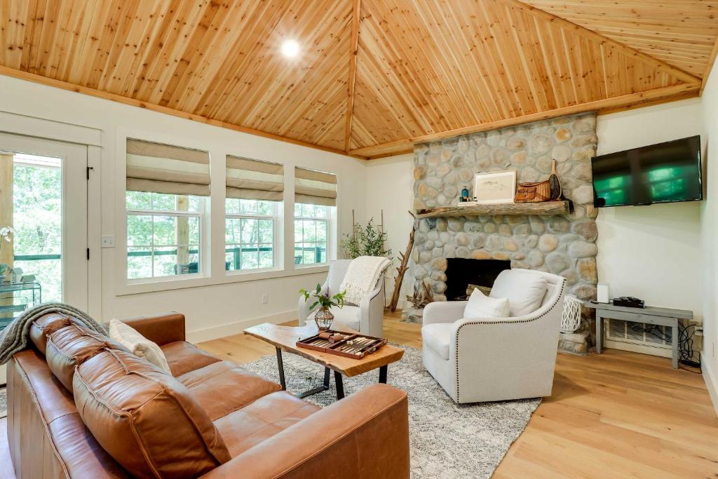uma sala de estar com um sofá e uma lareira de pedra em Spacious Home on Beaver Lake with Deck and Fire Pit! em Rogers
