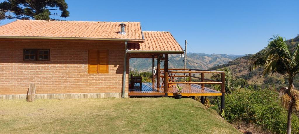 a small house with a large deck on a hill at Chalé Alto da Serra in Gonçalves