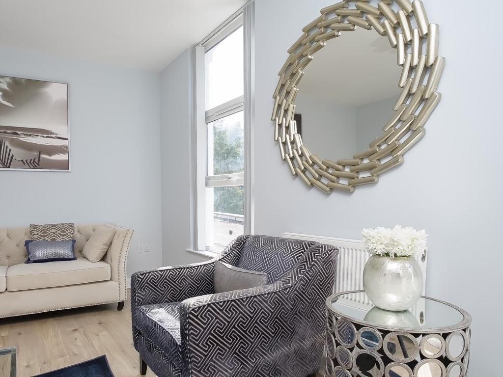 a living room with a chair and a mirror at City Centre 3 BDR Townhouse by Belfast City Breaks in Belfast