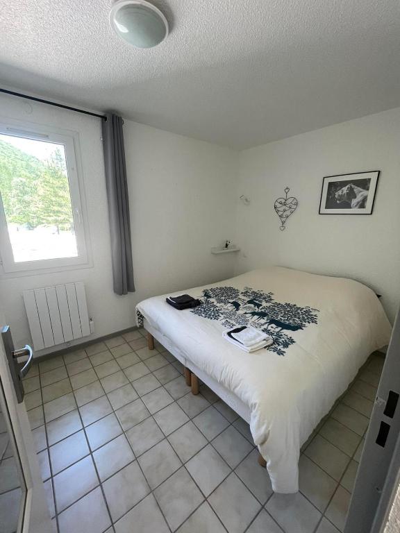 a bedroom with a bed in a room with a window at T2 au cœur de la nature de Digne in Digne-les-Bains