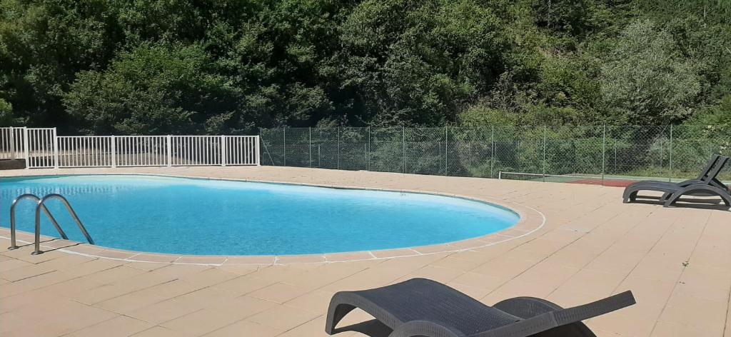 a swimming pool with two chairs on a patio at T2 au cœur de la nature de Digne in Digne-les-Bains