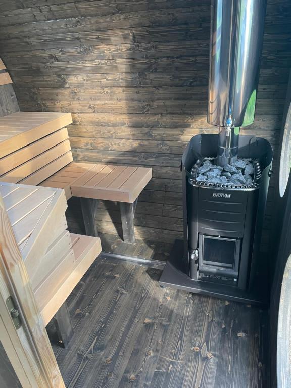 piec opalany drewnem w kabinie z ławką w obiekcie Flatmoen Natur Lodge w Alcie
