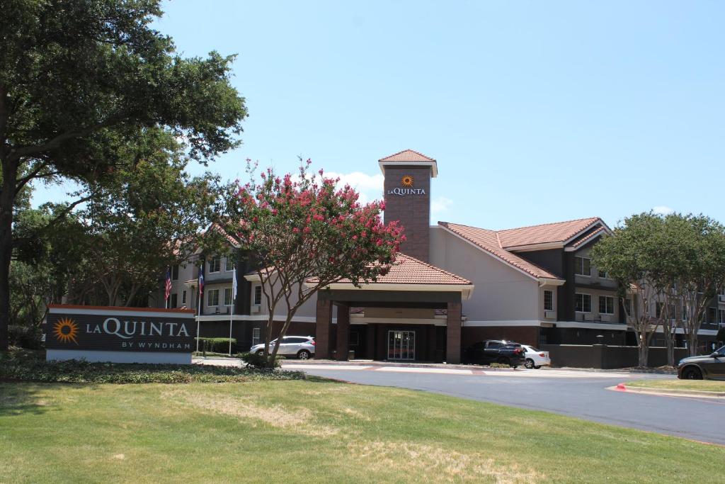 un hotel con un cartel frente a un edificio en La Quinta by Wyndham Dallas - Addison Galleria en Addison