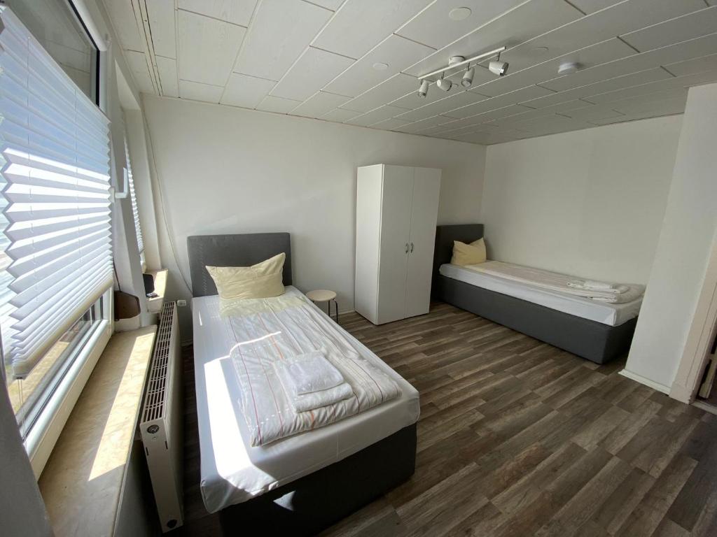 ノイミュンスターにある2-SZ Unterkunft nahe FEKのベッド2台と窓が備わる小さな客室です。