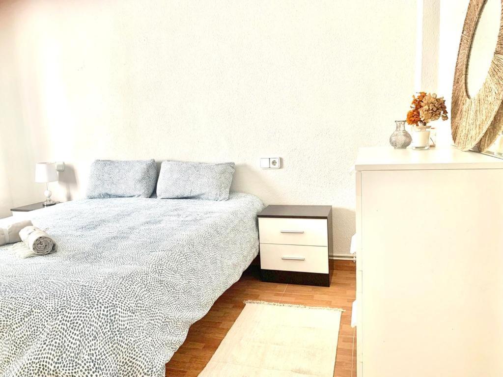 Habitación blanca con cama y mesita de noche en Apartamento a 200 metros paseo zorrilla en Valladolid