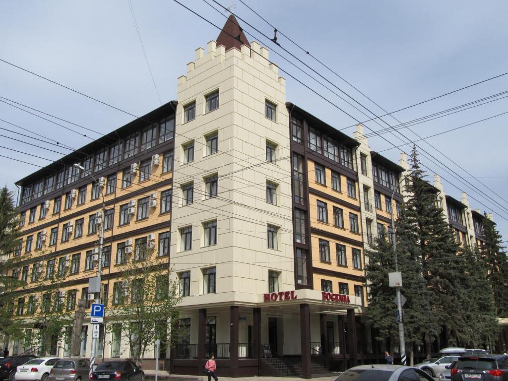 ein weißes Gebäude mit einem Dreieck darüber in der Unterkunft Bogemia Hotel on Vavilov Street in Saratow
