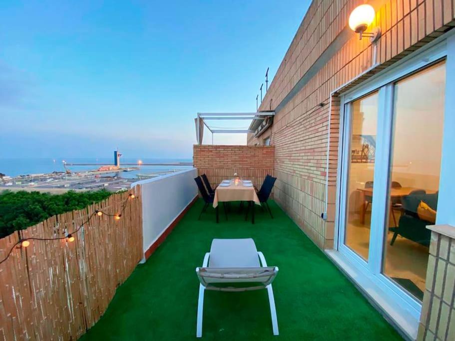 a balcony with green grass and a table and chairs at Luminoso ático con vistas al mar in Almería