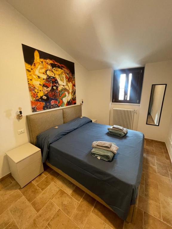 a bedroom with a bed and a painting on the wall at Le Finestre sul Duomo in LʼAquila