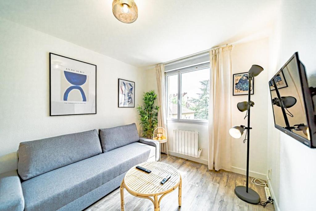 a living room with a blue couch and a table at Le petit Dauphiné-studio rénové-Sans soucis in Lyon