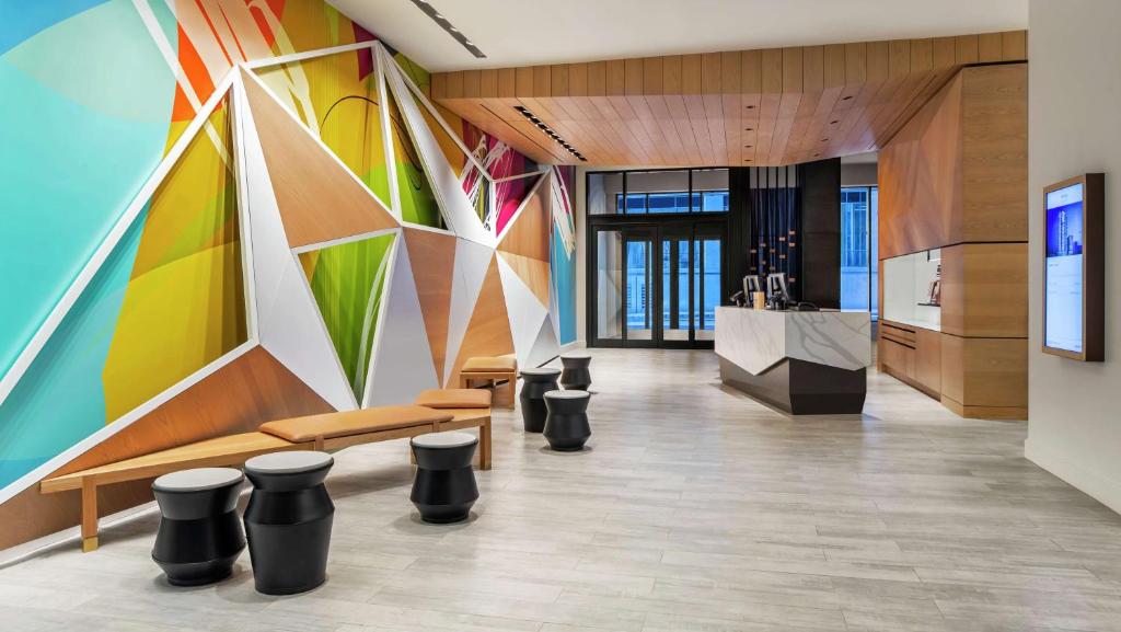 a lobby with a colorful wall with benches and stools at Canopy By Hilton Atlanta Midtown in Atlanta
