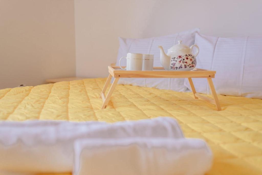 een houten tafel met een theeservies bovenop een bed bij Apartmani Šarović Tara 3 in Rača