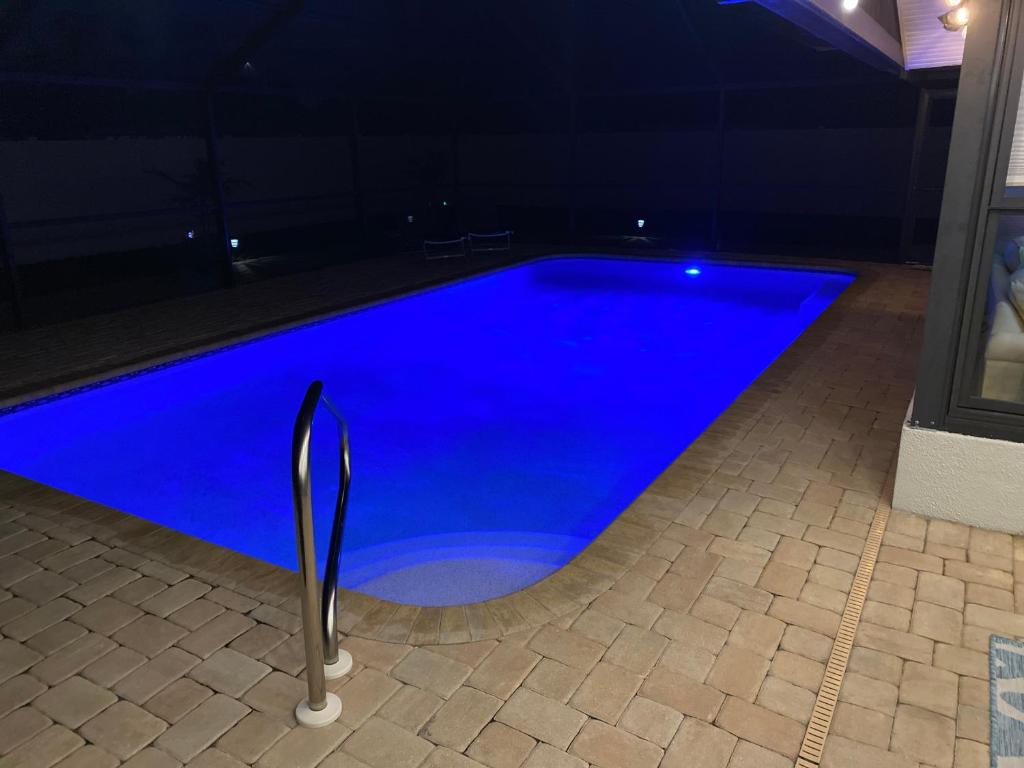 a blue swimming pool in a house at night at Venice Dream Vacations, Centrally Located, Just Waiting For You in Venice