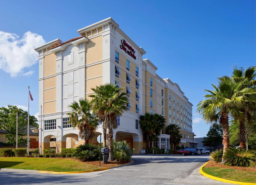 a hotel with palm trees in front of a street at Hampton Inn & Suites Savannah/Midtown in Savannah