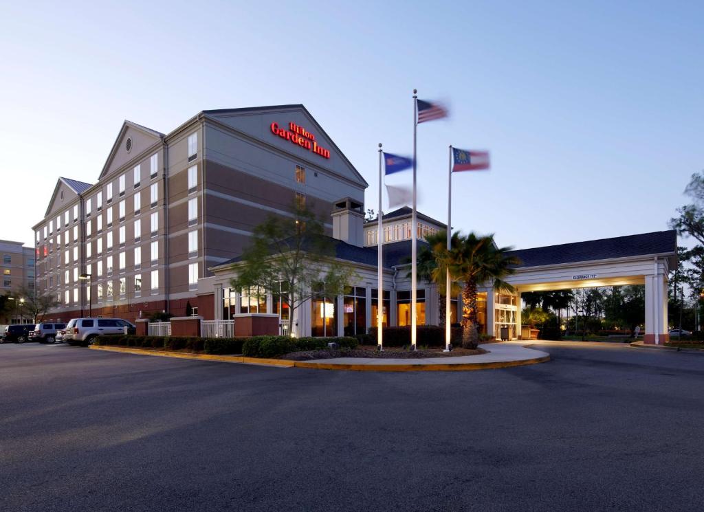 un hotel con bandiere di fronte a un edificio di Hilton Garden Inn Savannah Midtown a Savannah