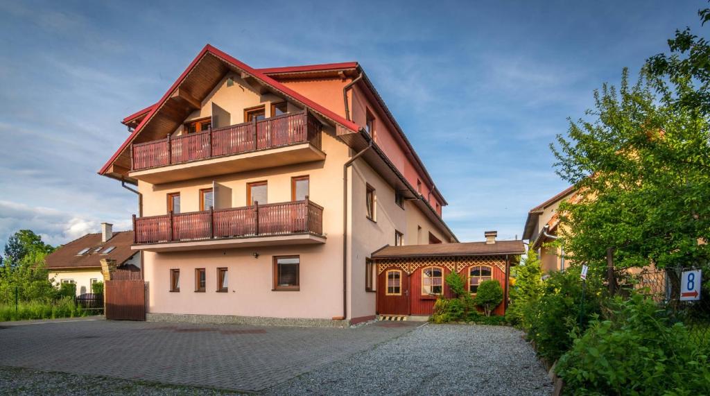 a house with a balcony on top of it at Apartmany Veverica in Liptovský Mikuláš