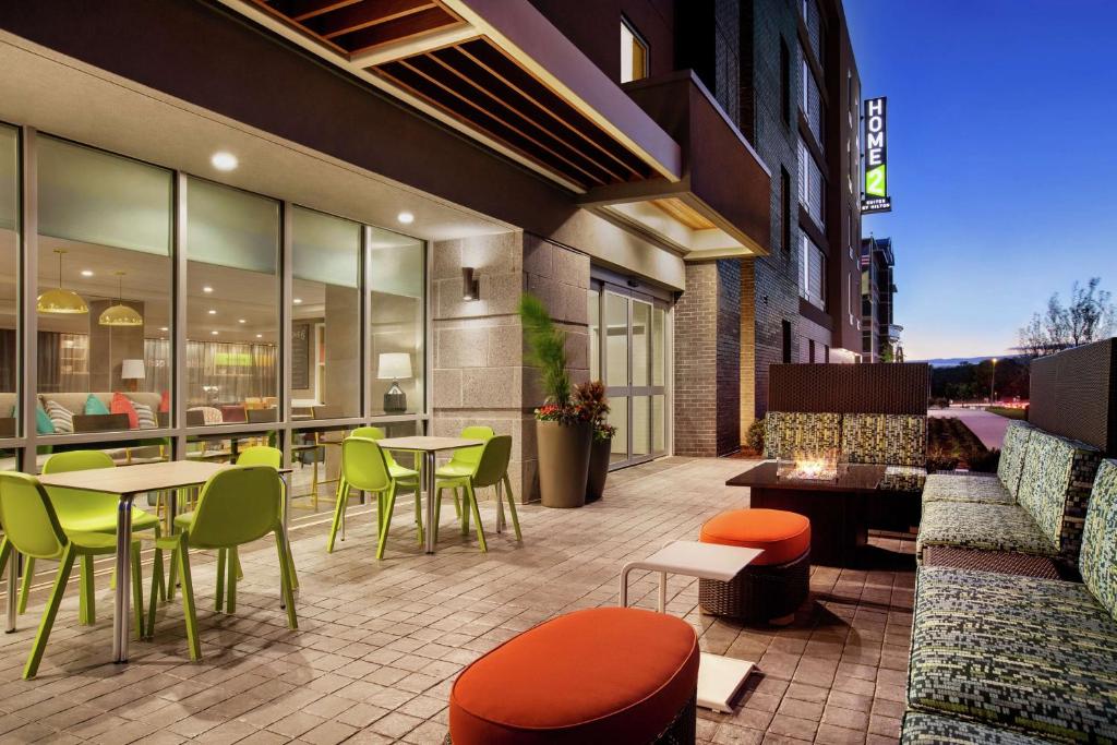 un patio con mesas y sillas en un edificio en Home2 Suites By Hilton Silver Spring, en Silver Spring