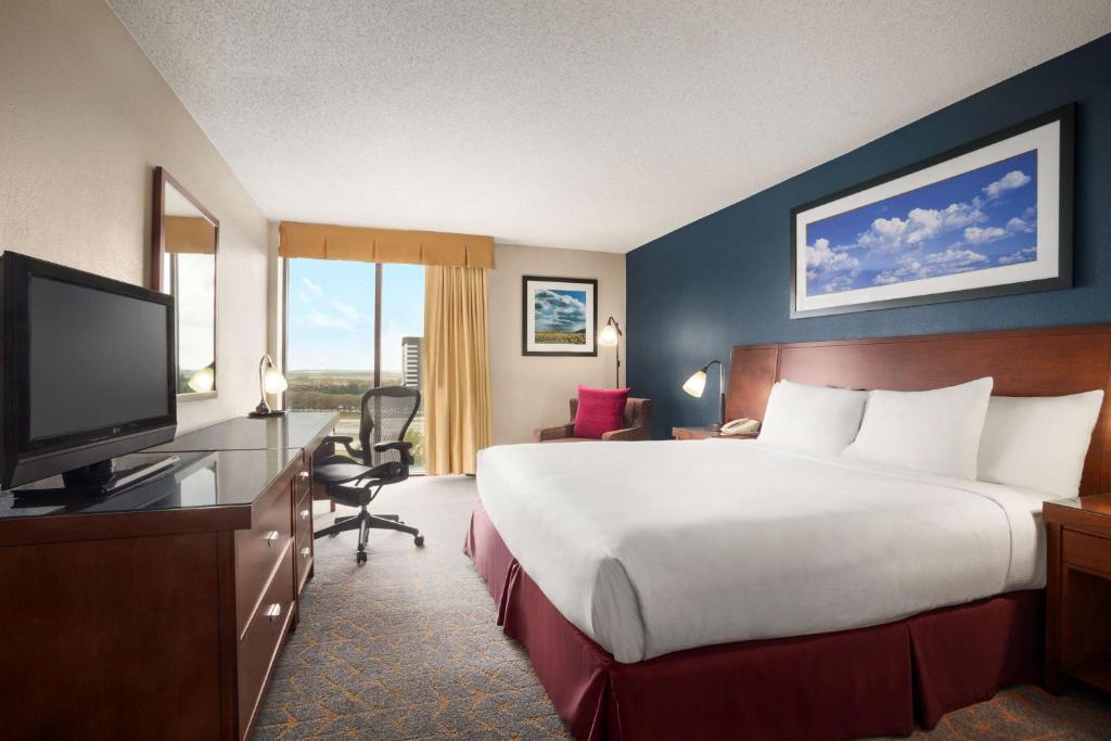 a hotel room with a large bed and a television at DoubleTree by Hilton DFW Airport North in Irving