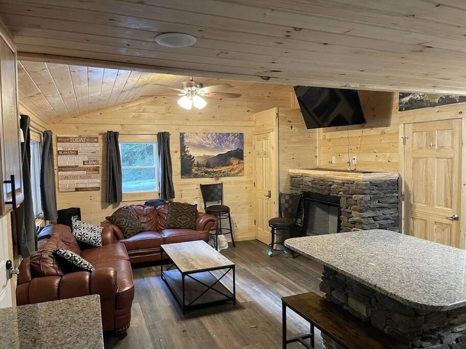 a living room with leather furniture and a fireplace at Creekside 3 bedroom 2 bath cabin on private creek in Banner Elk
