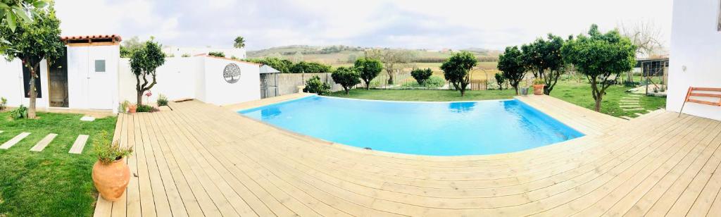 - une grande piscine dans une cour à côté d'une maison dans l'établissement Varzea Nature, à Torres Vedras