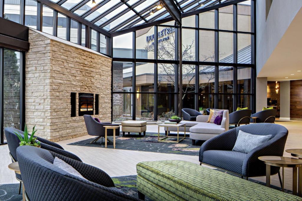 a lobby with chairs and tables and windows at DoubleTree by Hilton Fairfield Hotel & Suites in Fairfield