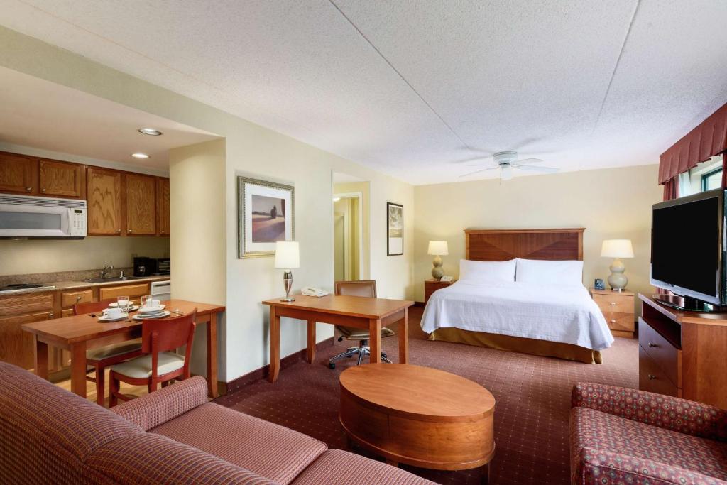 a hotel room with a bed and a kitchen at Homewood Suites by Hilton Newark-Wilmington South Area in Newark