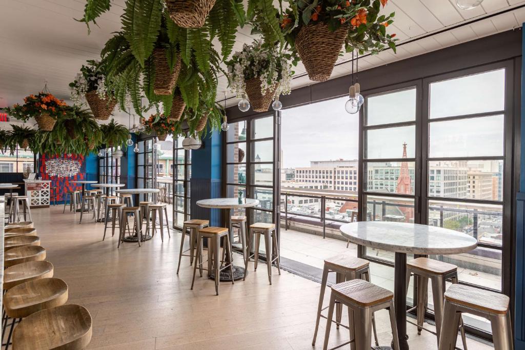 een restaurant met tafels, stoelen en ramen bij Motto by Hilton Washington DC City Center in Washington