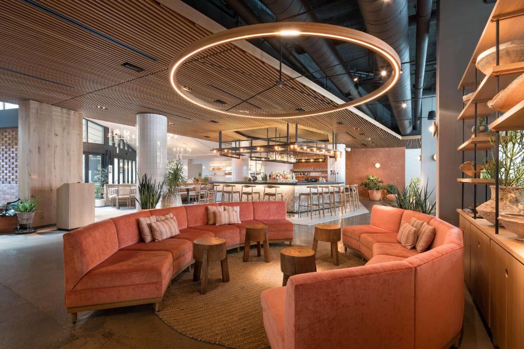 a lobby with orange couches and a bar at Motto by Hilton Philadelphia Rittenhouse Square in Philadelphia