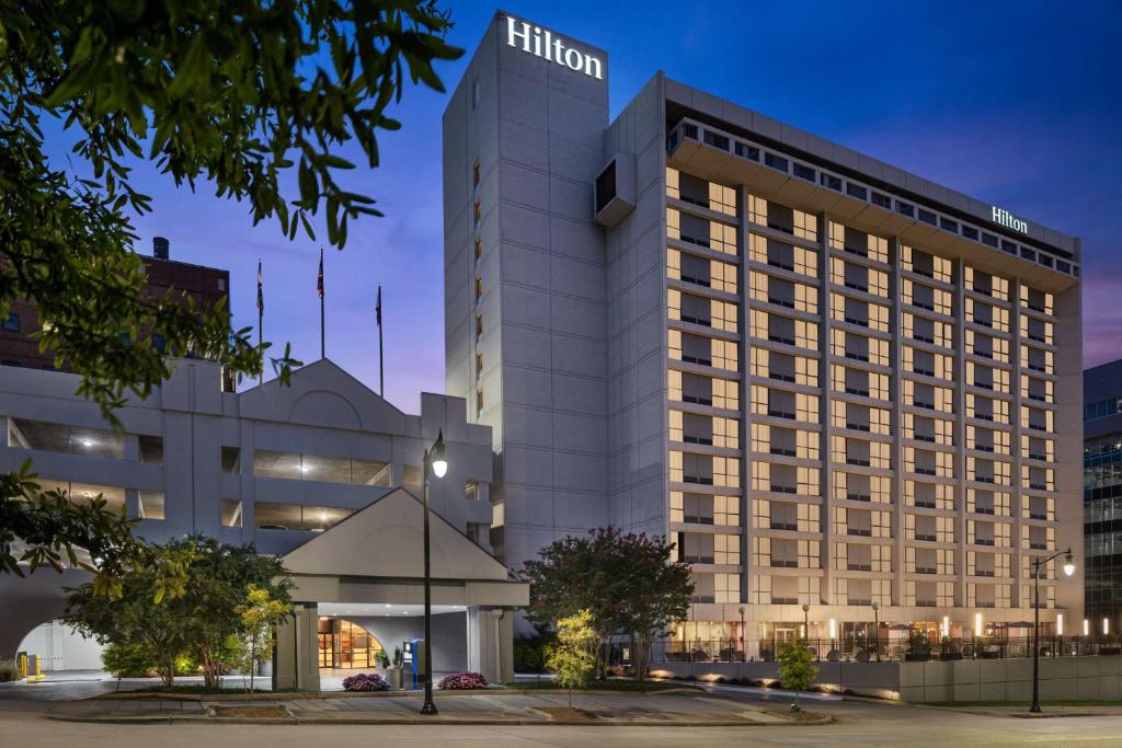 Hilton Birmingham Downtown at UAB في برمنغهام: مبنى مضاء مع فندق هيلتون