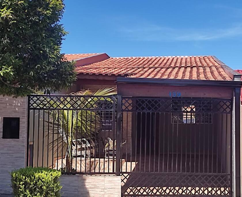 um edifício com um portão em frente a uma casa em Gray House 1 - JD Santiago em Londrina