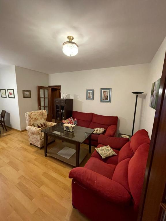 a living room with a red couch and a table at Apartamento Vallehermoso in El Puerto de Santa María