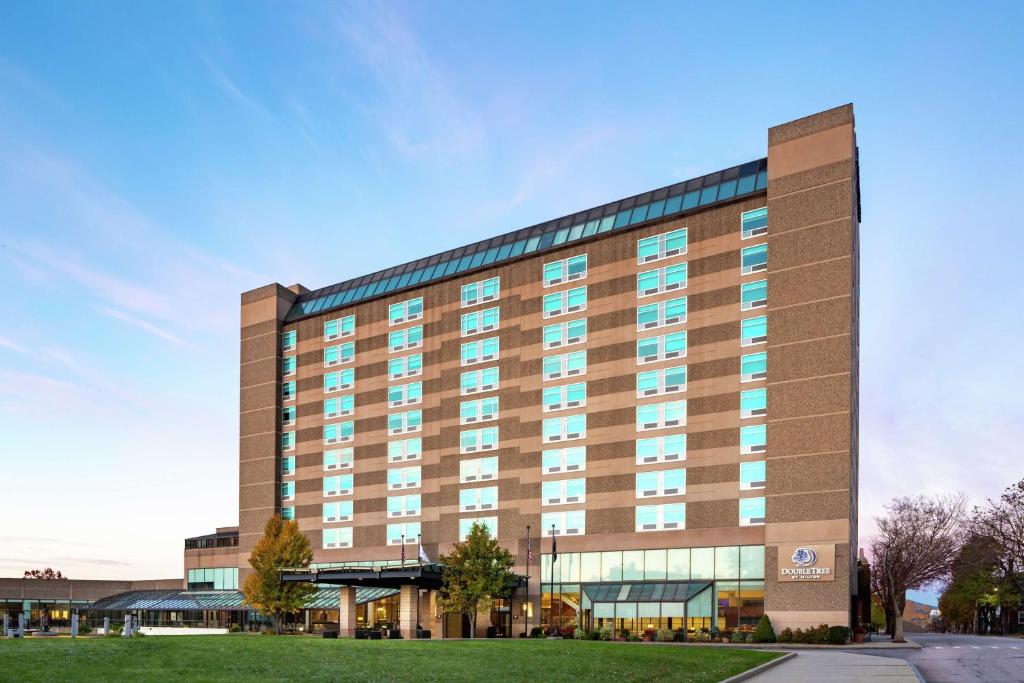 a large hotel building with a lawn in front of it at DoubleTree by Hilton Manchester Downtown in Manchester