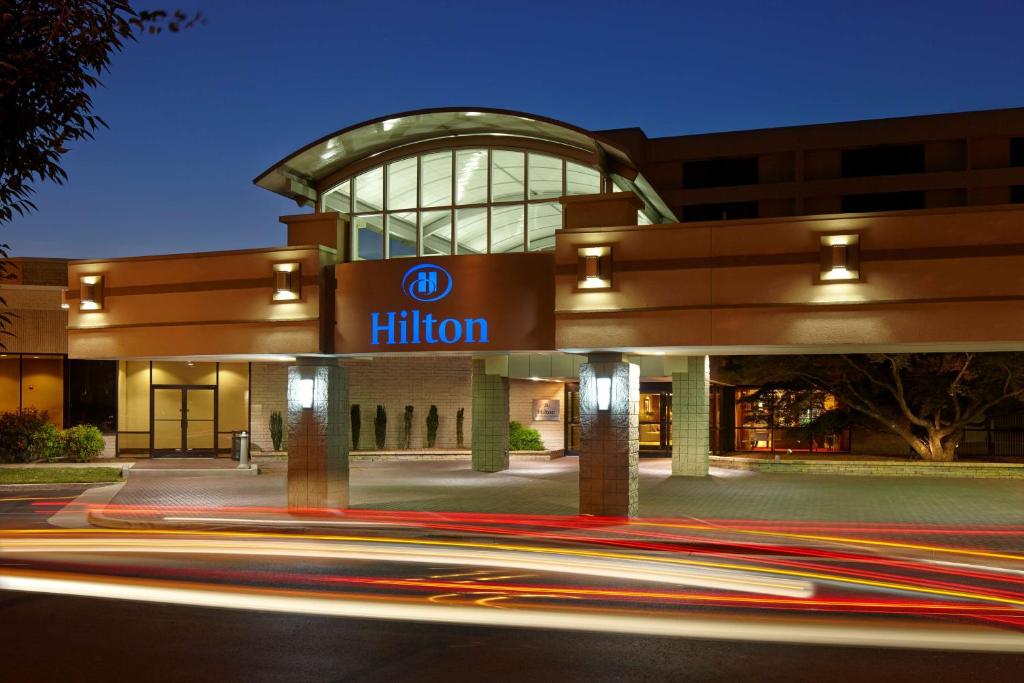 un edificio con un cartel de hilton por la noche en Hilton Raleigh North Hills en Raleigh