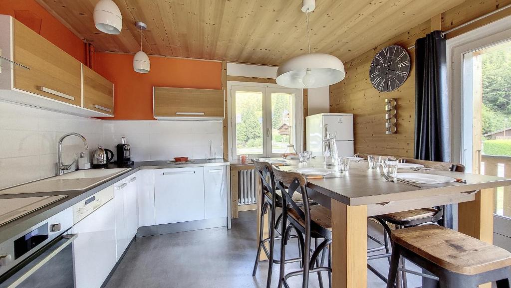 een keuken met een houten plafond en een tafel met stoelen bij la ranche in Montriond