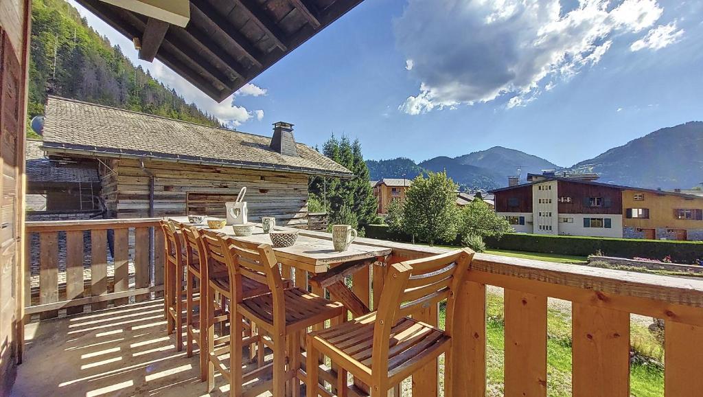 a wooden deck with a table and chairs on it at la ranche in Montriond